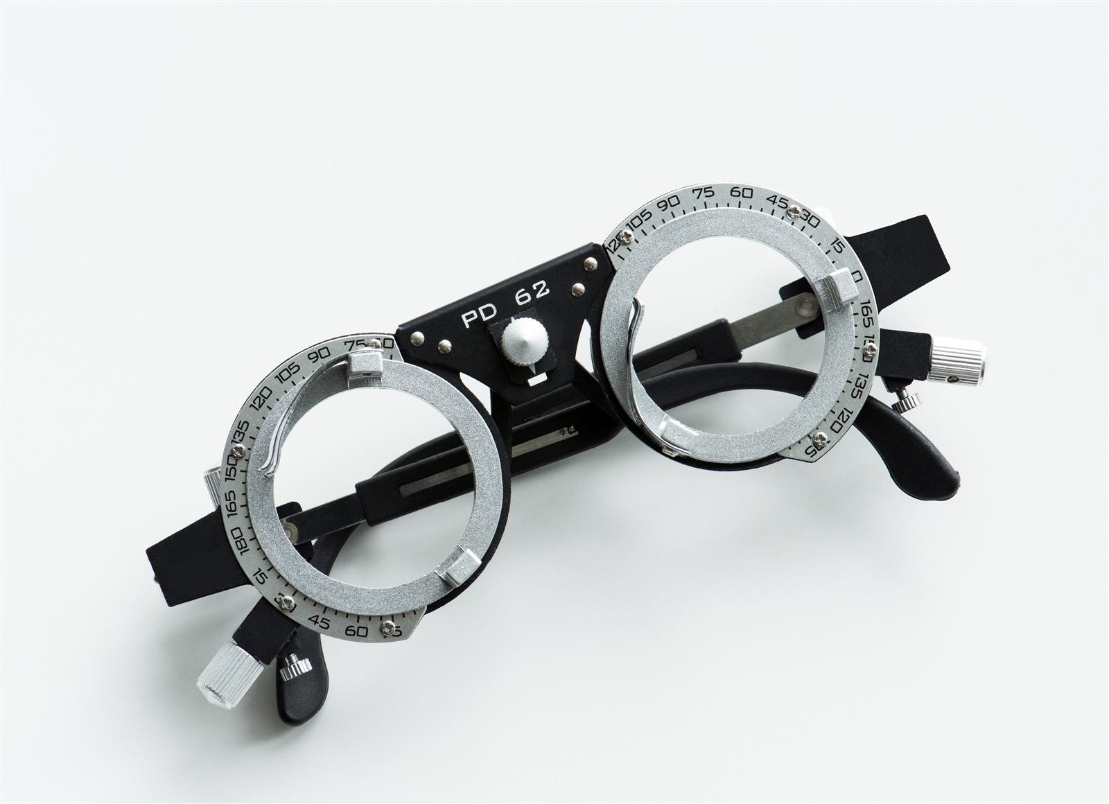 Optician carefully measuring a pair of eyeglasses