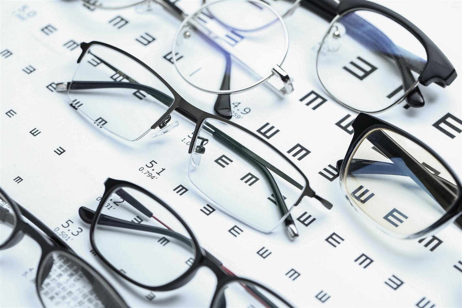 Prescription glasses beside an eye chart